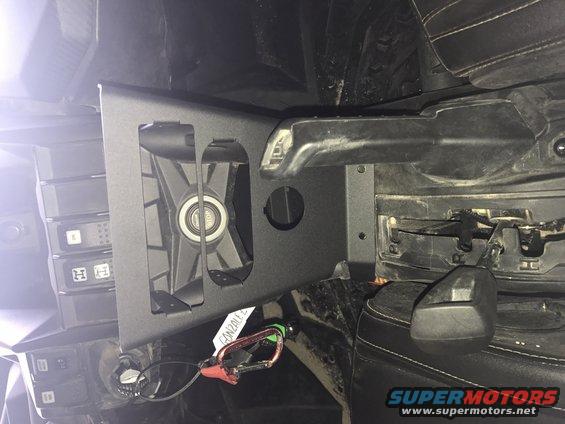 Interior view of a vehicle part with a fan, carabiner, and some electronic components