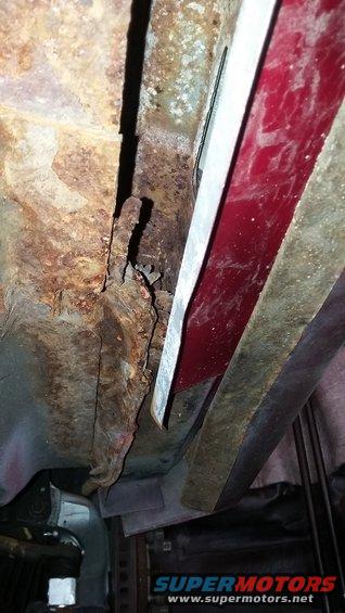 Undercarriage rust on red vehicle part