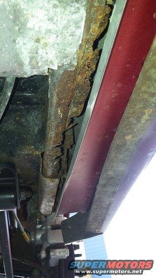 Close-up of heavily rusted metal frame and undercarriage components
