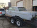 1962 Ford Galaxie - The body of a 1962 Ford Galaxie is transported on a trailer, revealing its weathered condition and incomplete front assembly.