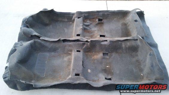 Dark gray car interior carpet with cutouts for floor mounts