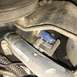 1979 Ford Ranchero - Close-up view of an engine component a blue sensor and a hose marked '3/4 INCH'.