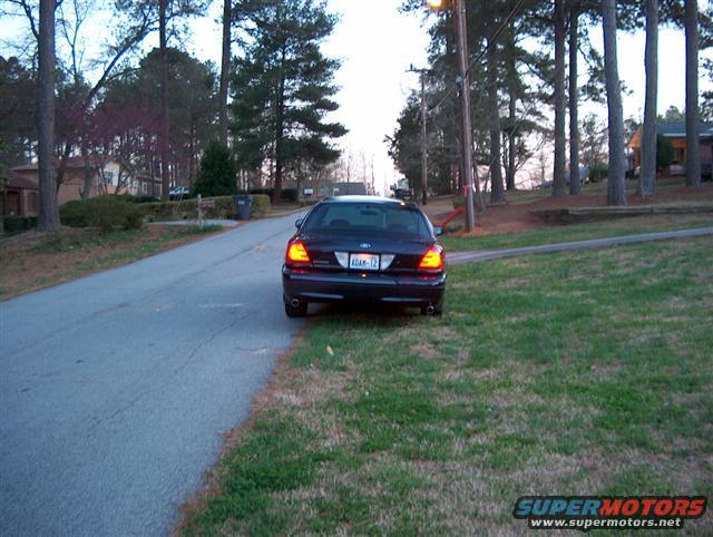 Dark 2001 Ford Crown Victoria rear view, parked on grass
