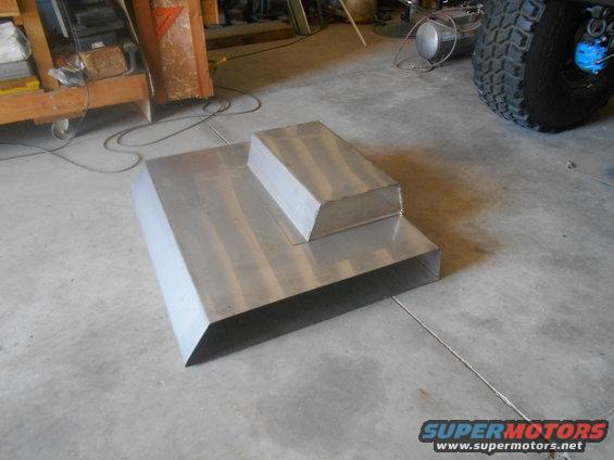 Aluminum fabrication with a raised section sits on a concrete floor