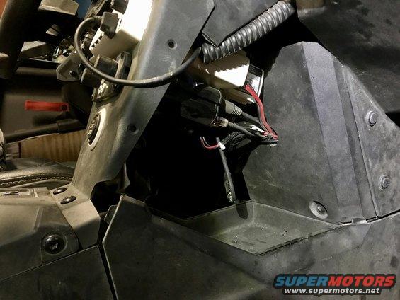 Close-up of wiring and components in a vehicle's dashboard area