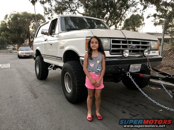1988 Ford Bronco lifted with large tires, girl standing in front. California license plate 5TBV665