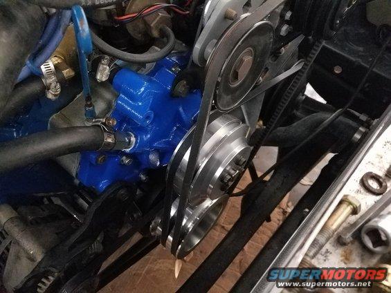 Engine with blue painted water pump and multiple belts and pulleys