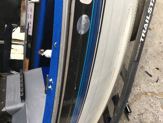 Boat interior with blue carpet and white fire extinguisher