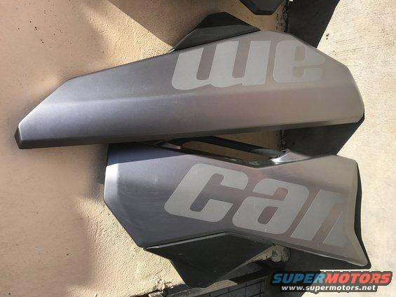 Two gray plastic body panels with white lettering 'we' and 'can'