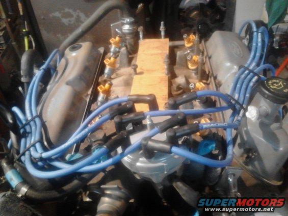 Engine with blue spark plug wires and yellow fuel injectors