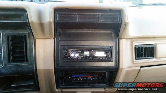 Car dashboard interior with Pioneer stereo and air vents. Beige and black trim