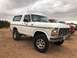 1978 Ford Bronco - This white 1978 Ford Bronco is parked outdoors with other vehicles in the background.