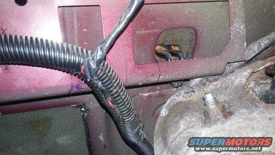 Close-up of a red vehicle's wiring harness and some metal components