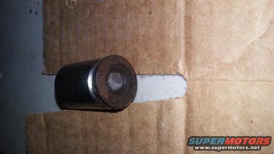Metal cylinder with a hole in the center, resting on cardboard