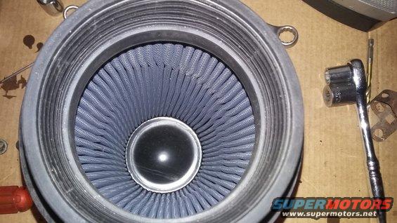 Close-up of a blue air filter with a socket wrench nearby