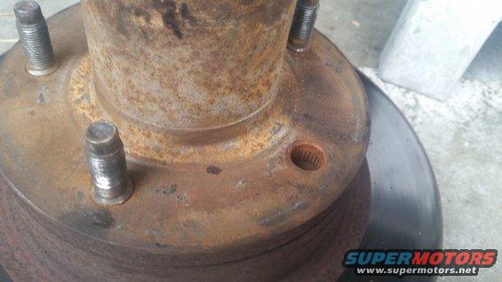 Rusted wheel hub with four studs and a brake rotor