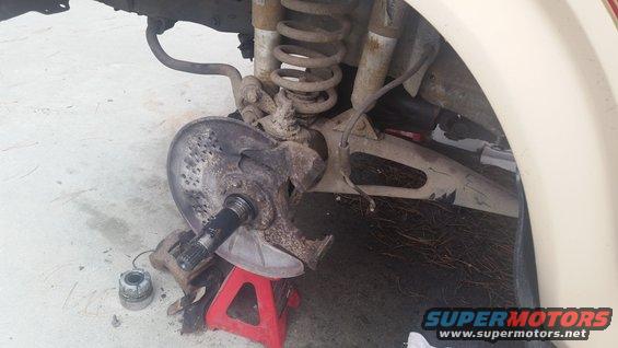 Front wheel assembly on red jack stand, showing brake rotor and suspension components