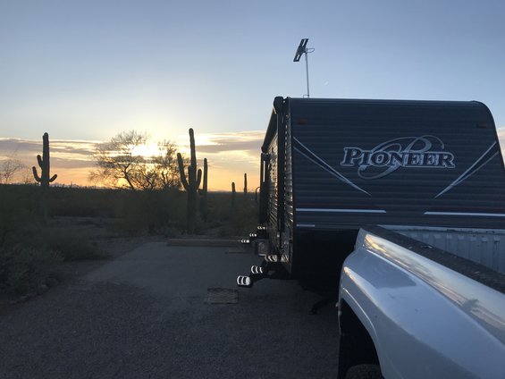 Pioneer travel trailer and pickup truck bed at sunset with saguaro cacti