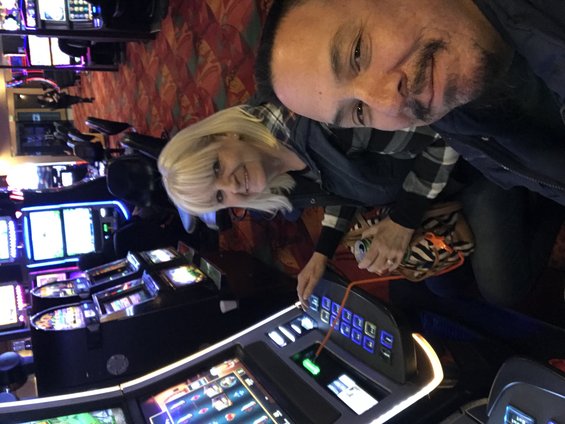 Casino interior with slot machines and people playing