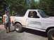 1996 Ford Bronco - A white 1996 Ford Bronco is shown from the front-three-quarter angle, with a person standing next to the driver's side door.
