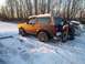 1982 Honda XL250R - A brown Ford Bronco is parked in the snow with a dirt bike mounted on a rear rack. Another car is visible to the right.