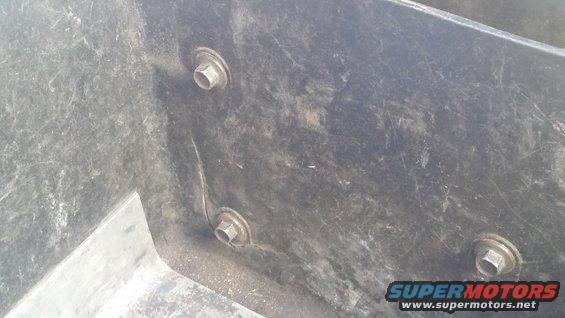 Black plastic underhood toolbox with three visible bolts and scratches