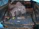 1986 Ford Bronco - The interior of a truck bed shows significant rust and is filled with removed insulation and various tools.