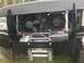 1989 Ford Bronco - The front of a 1989 Ford Bronco features a winch and dual cooling fans mounted behind a custom bumper.