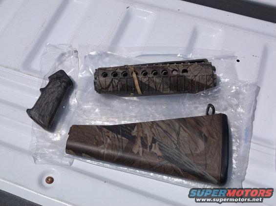 Camouflage gun stock and forend parts laid out on a white surface