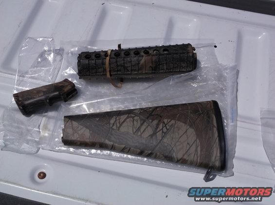 Camouflage gun stock and forend parts laid out on a white surface