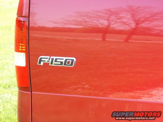 Red Ford F-150 tailgate with F-150 badge and Supermotors.net logo
