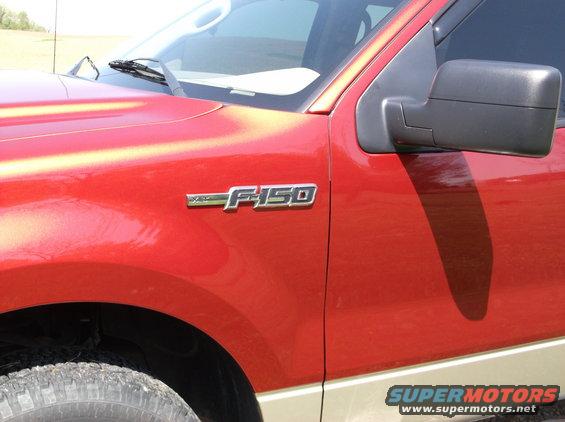 Red truck fender with F-150 badge and black side mirror