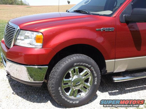 Red Ford F-150 truck, front quarter view. Shows chrome grille, headlights, and "F-150" badge