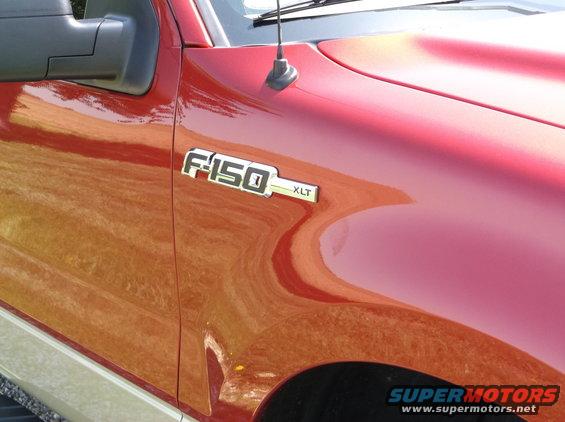 Close-up of F-150 XLT badge on a red truck fender