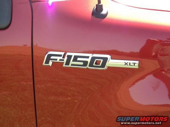Close-up of a 2008 Ford F-150 XLT emblem on a red truck door