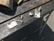 1989 Ford Bronco - Various metal parts are laid out on a wooden surface, possibly for repair or fabrication.