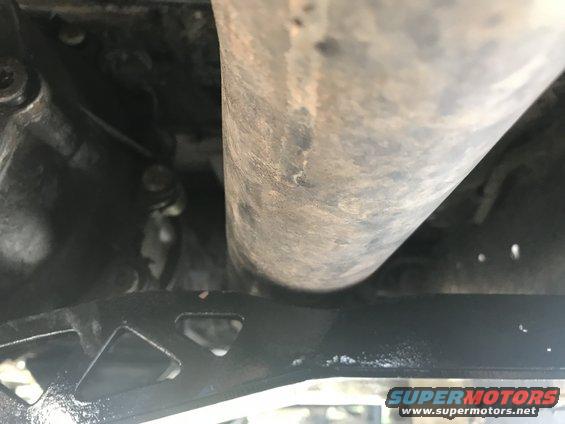 Close-up of a large exhaust pipe over a black metal frame with triangular cutouts