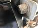 1989 Ford Bronco - Detail of a black metal component and a bolt, possibly related to a vehicle's transfer case.