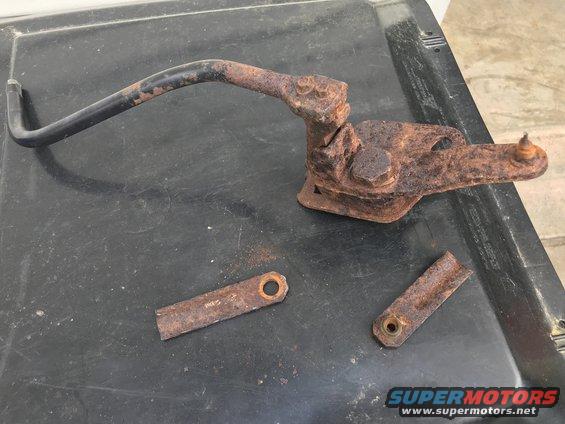 Rusted transfer case linkage parts on a black surface