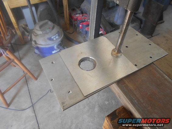 Metal plate with hole and screw mechanism, part of a larger assembly