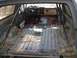 1986 Ford Bronco - Interior of a stripped-down SUV, likely from the 1980s, with a roll cage installed.