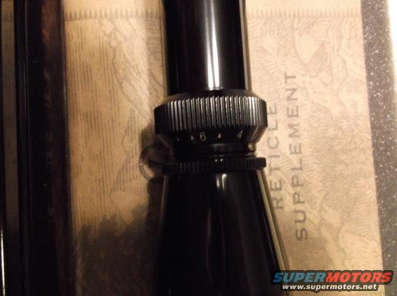Black rifle scope with magnification adjustment ring showing numbers 4 and 6