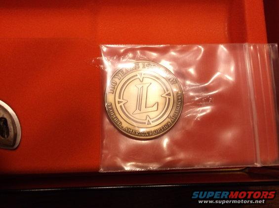 Coin in plastic packaging on orange surface