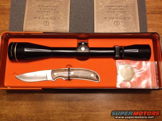 Rifle scope and knife in an orange box with Leupold documentation