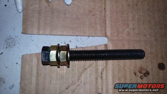 Bolt with two nuts and washers on cardboard