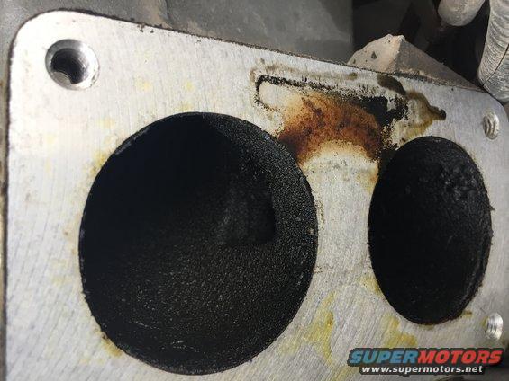 Close-up of an engine intake manifold with carbon buildup in the ports