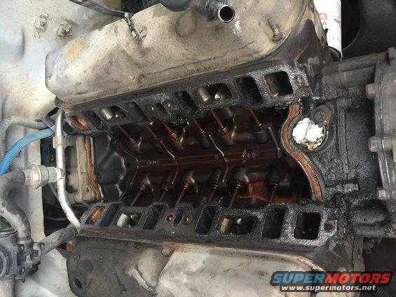 Engine block with intake manifold removed, showing internal components and oil residue