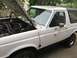 1990 Ford Bronco - The hood of this white 1990 Ford Bronco is open, revealing the engine compartment.
