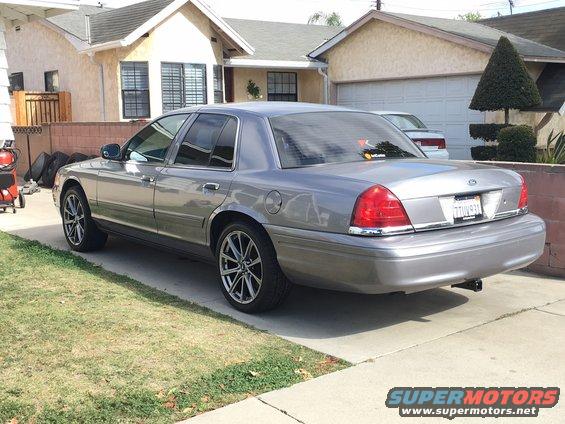 Gray Ford Crown Victoria parked in driveway, rear view. License plate reads TTUV931