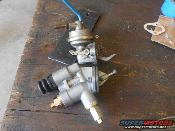 Two mechanical fuel pumps on a wooden workbench
